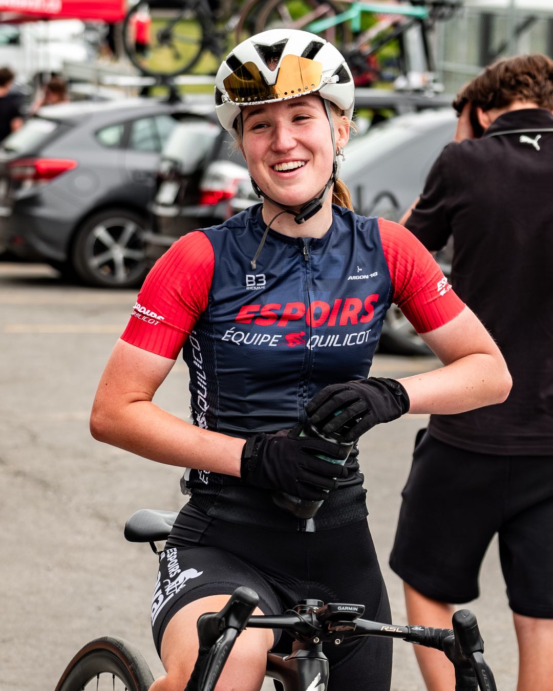 Une athlète souriante essaie d'ouvrir sa bouteille d'eau.