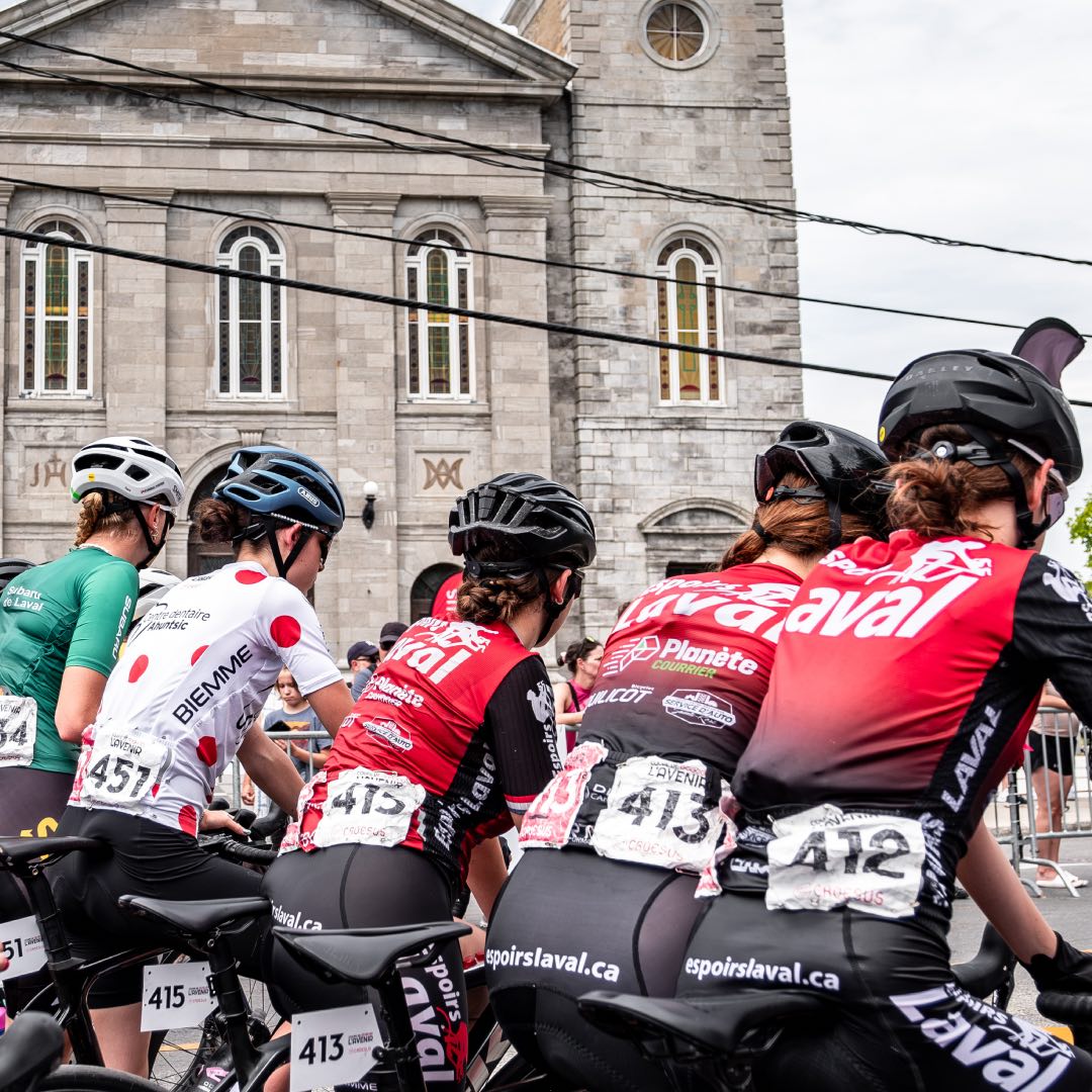 Vue de dos, ses athlètes sont placés sont placés sur la ligne de départ et attendent de s'élancer.