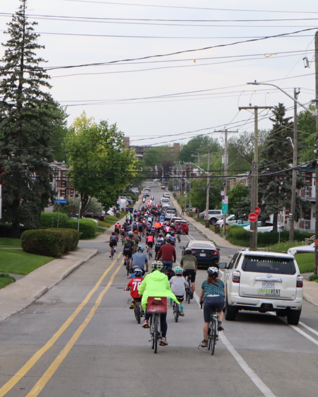 Des personnes roulent sur des vélos dans une rue balisée par la police. 